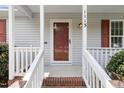 Close-up of the front porch with a red front door, white railing, and brick steps at 1113 Curtiss Dr, Garner, NC 27529