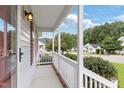 Side view of the front porch featuring white railings and views of the neighborhood at 1113 Curtiss Dr, Garner, NC 27529