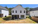 Back exterior of home with a screened-in porch and lounge chairs on a patio at 12658 W Hanes Ave, Middlesex, NC 27557