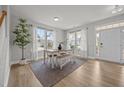 Bright dining area featuring hardwood floors, a stylish table setting, and large windows with sheer curtains at 14 Shady Oaks Rd, Angier, NC 27501