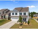 Beautiful two-story home with a manicured lawn, attached garage, and welcoming porch with comfortable seating at 14 Shady Oaks Rd, Angier, NC 27501