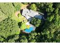 Aerial view of estate featuring a pool surrounded by mature trees, a back patio and lush landscaping at 14236 Wyndfield Cir, Raleigh, NC 27615