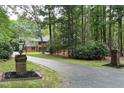 Long paved driveway leading to a brick home surrounded by lush trees and landscaping at 14236 Wyndfield Cir, Raleigh, NC 27615