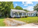 A charming single-story home is displayed with a gravel driveway and manicured lawn at 1543 Wickham St, Burlington, NC 27215