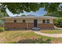 Charming single-story home with a brick facade, blue front door, manicured lawn, and mature trees at 2014 Athens Ave, Durham, NC 27707
