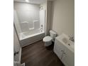 Bright bathroom featuring a tub and shower combination, toilet, and single sink vanity at 203 Hope St, Erwin, NC 28339