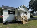 Beautiful exterior showcasing a white home with black shutters and a wooden porch at 203 Hope St, Erwin, NC 28339