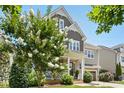 Charming two-story home showcasing a well-maintained front yard, a blend of brick and siding, and a beautiful tree at 205 Aurora Rd, Hillsborough, NC 27278