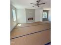 Bright living room featuring a modern ceiling fan, large windows and a cozy fireplace at 213 Maye St, Dunn, NC 28334