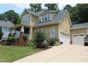 Charming two-story home with a well-manicured lawn, two-car garage, and neutral-toned exterior at 221 Grantwood Dr, Holly Springs, NC 27540