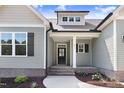 Inviting entryway showcasing a beautifully landscaped path leading to the front door with gray and white accents at 222 Cherrybirch Ln, Zebulon, NC 27597