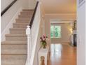 Bright foyer with staircase featuring carpeted stairs and a view into the living room at 2222 Pathway Dr, Chapel Hill, NC 27516
