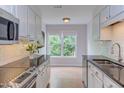 Well-lit kitchen features white cabinets, granite countertops, and a window with a view at 2222 Pathway Dr, Chapel Hill, NC 27516