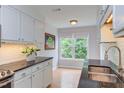 Well-lit kitchen features white cabinets, granite countertops, and a window with a view at 2222 Pathway Dr, Chapel Hill, NC 27516