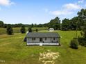 Inviting front exterior of a single story home surrounded by luscious green grass and a well kept lawn at 224 Grameta Ln, Lillington, NC 27546