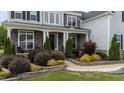 Charming home exterior with stone accents, manicured landscaping, and covered front porch entrance at 228 Cloverdale Rd, Apex, NC 27523