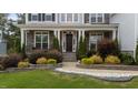 Close-up of inviting home with stone accents, manicured landscaping, and covered front porch at 228 Cloverdale Rd, Apex, NC 27523