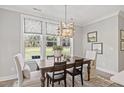 Well-lit dining area features a wooden table and large windows offering a view of the backyard at 23 W Victoria Ridge Dr # 33, Selma, NC 27576