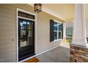 Stylish front door with glass panels, complemented by a cozy porch and stone-detailed column at 262 Salt Cedar Ln, Chapel Hill, NC 27516
