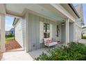 Cozy, covered porch features a comfortable seating area and view of the landscaped front yard at 2806 High Plains Dr, Fuquay Varina, NC 27526