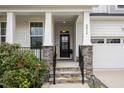 Inviting front porch with stone accents and manicured landscaping at entrance at 2914 Farmhouse Dr, Apex, NC 27502