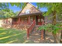 Charming home featuring a brick foundation, wood siding, covered porch, and brick steps at 3129 Tarheel Clubhouse Rd, Raleigh, NC 27604