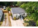 Aerial view of a well-maintained white home with manicured lawn, complemented by a long driveway at 3649 Guess Rd, Durham, NC 27705