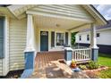 Inviting front porch with cozy seating, complemented by blue trim and a neatly kept garden bed at 408 N Fourth/ 4Th St, Mebane, NC 27302