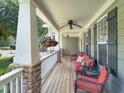 Inviting front porch with comfortable seating, ceiling fan, and hanging flower baskets, perfect for relaxing at 4416 Brighton Ridge Dr, Apex, NC 27539