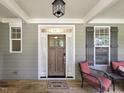 Charming front porch with wood door, welcome mat, and cozy seating area at 4416 Brighton Ridge Dr, Apex, NC 27539