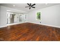 Sun-filled living area with hardwood floors, a ceiling fan, and open access to the modern kitchen at 4428 W West River Rd, Franklinton, NC 27525