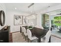 Elegant dining room features modern lighting, dark wood table, and access to an outdoor patio at 45 Shady Creek Way, Fuquay Varina, NC 27526