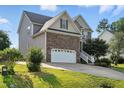 Two-story home showcasing a brick and siding exterior, a two-car garage, and a green lawn at 456 Majestic Oak Dr, Garner, NC 27529