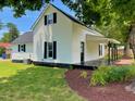 Charming two-story home with white siding, black shutters, and a well-maintained lawn and landscaped garden at 510 May St, Gibsonville, NC 27249