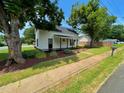 Charming two-story home with white siding, black shutters, and a cozy front porch with landscaping at 510 May St, Gibsonville, NC 27249