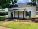 Charming front porch with black painted deck, with hanging plants and sidewalk approach at 510 May St, Gibsonville, NC 27249