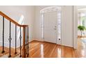 Bright entryway with hardwood floors and decorative glass door and staircase with wood handrail at 5818 Myakka Ct, Raleigh, NC 27616