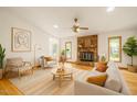 Bright living room featuring a stone fireplace, hardwood floors, and neutral decor with access to the screened porch at 601 Wofford Rd, Durham, NC 27707