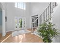 Grand foyer featuring high ceilings, hardwood floors, staircase, and an abundance of natural light at 602 Preston Village Way, Cary, NC 27519