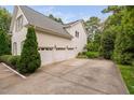 Side view of house featuring a spacious three-car garage and extended concrete driveway at 602 Preston Village Way, Cary, NC 27519