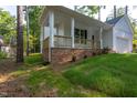 Inviting covered porch with brick base and wooden railings, perfect for outdoor enjoyment at 6069 Jones Cir, Sanford, NC 27332