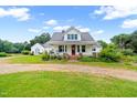 Classic farmhouse with covered porch, vibrant landscaping, and spacious front yard at 6318 Hurdle Mills Rd, Roxboro, NC 27574