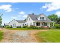 Picturesque farmhouse with a metal roof, inviting porch, and sprawling yard at 6318 Hurdle Mills Rd, Roxboro, NC 27574