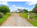 Expansive property showcasing a well-maintained lawn, long driveway, and classic farmhouse architecture at 6318 Hurdle Mills Rd, Roxboro, NC 27574