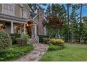 Beautiful home featuring stone accents, a stone chimney, and professionally landscaped surroundings at 633 Rolling Springs Dr, Cary, NC 27519