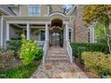 Inviting front porch with stone steps, columns, and lush landscaping for a warm welcome at 633 Rolling Springs Dr, Cary, NC 27519