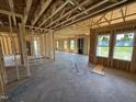 Unfinished living room with exposed wood beams and window placement shows a versatile design at 76 Tuskeegee Dr, Smithfield, NC 27577