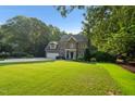 Traditional brick two-story home featuring an attached two-car garage and lush landscaping at 7713 Summercrest Dr, Apex, NC 27539