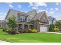 Beautifully landscaped home with a lush lawn, stone accents, and a welcoming two-car garage at 824 Stanly House St, Wake Forest, NC 27587