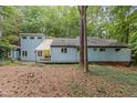 Exterior view of the home showcasing the backyard and wooded setting at 908 Cedar Fork Trl, Chapel Hill, NC 27514